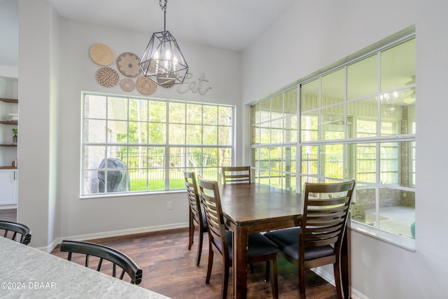 dining area featuring dark hardwood / wood-style flooring and an inviting chandelier