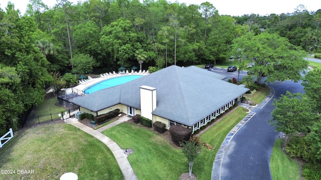 drone / aerial view of a heavily wooded area and a pool