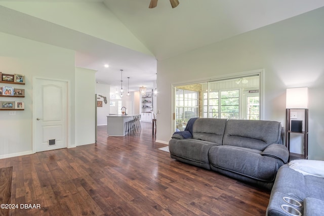 living area featuring dark wood-type flooring, high vaulted ceiling, ceiling fan, and baseboards