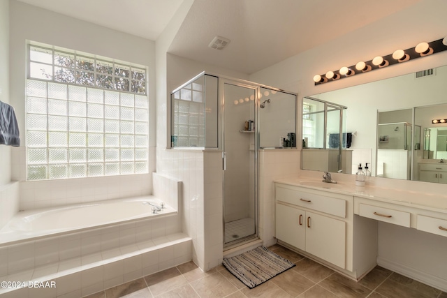 full bathroom featuring plenty of natural light, a stall shower, a garden tub, and vanity