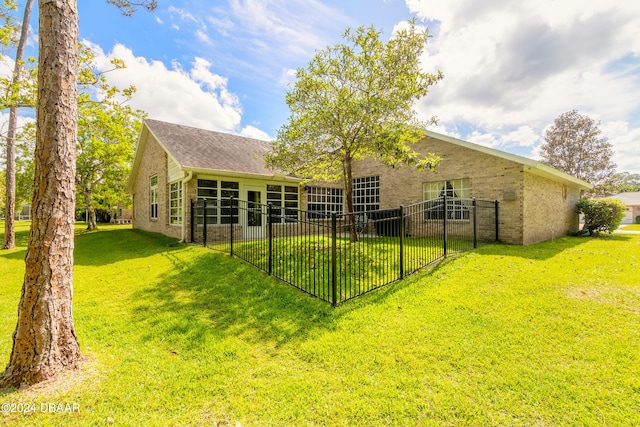 rear view of house featuring a lawn