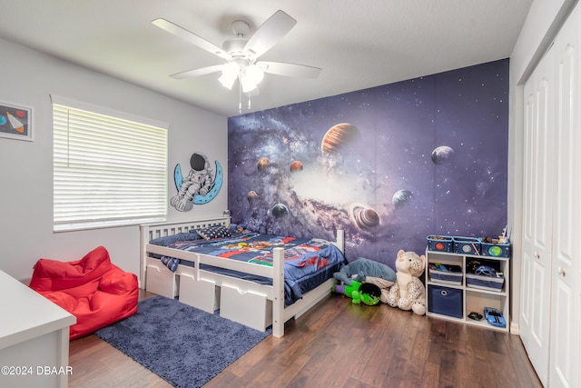 bedroom with hardwood / wood-style flooring, ceiling fan, and a closet