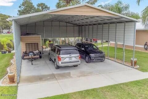 view of parking with a yard and a carport