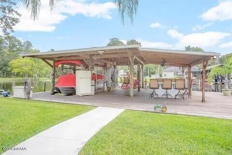 view of community featuring an outdoor bar, a water view, a yard, and a gazebo