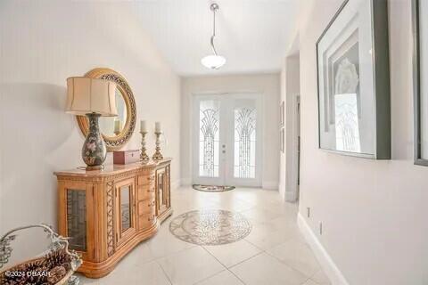 foyer entrance with light tile patterned floors and french doors