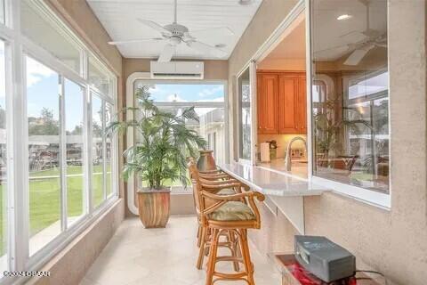 sunroom / solarium with ceiling fan and an AC wall unit