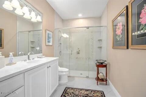 bathroom featuring walk in shower, vanity, and toilet