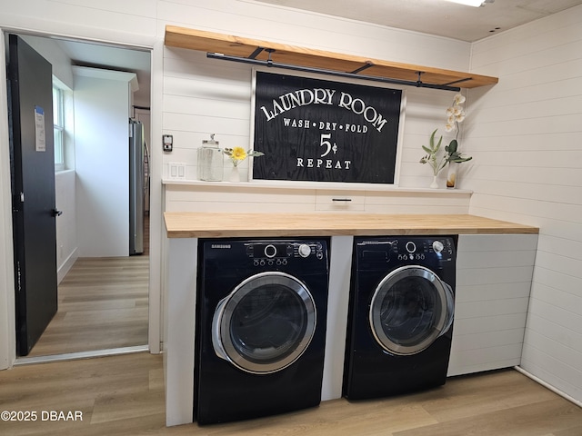 550 Eagle Dr, Holly Hill, FL 32117 - washroom featuring washer and dryer, light wood-type flooring, and wooden walls