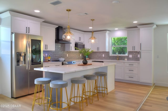 550 Eagle Dr, Holly Hill, FL 32117 - kitchen featuring appliances with stainless steel finishes, wall chimney range hood, white cabinetry, a kitchen island, and recessed lighting