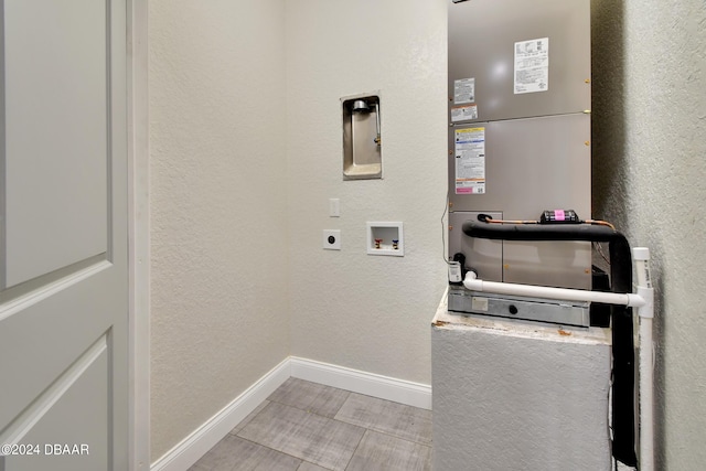 laundry room featuring electric dryer hookup, light tile patterned floors, and washer hookup