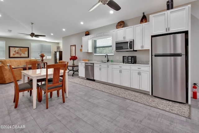 kitchen with white cabinets, appliances with stainless steel finishes, ceiling fan, and sink