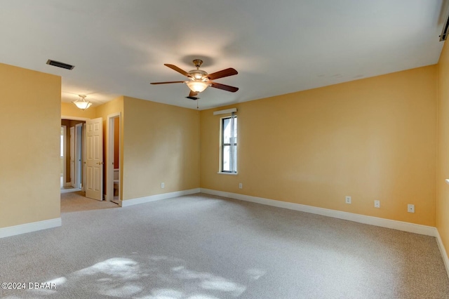 spare room featuring light colored carpet and ceiling fan