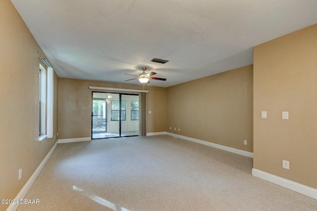 spare room with ceiling fan and light colored carpet