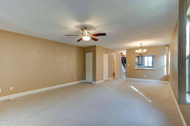 unfurnished room featuring carpet flooring and ceiling fan with notable chandelier