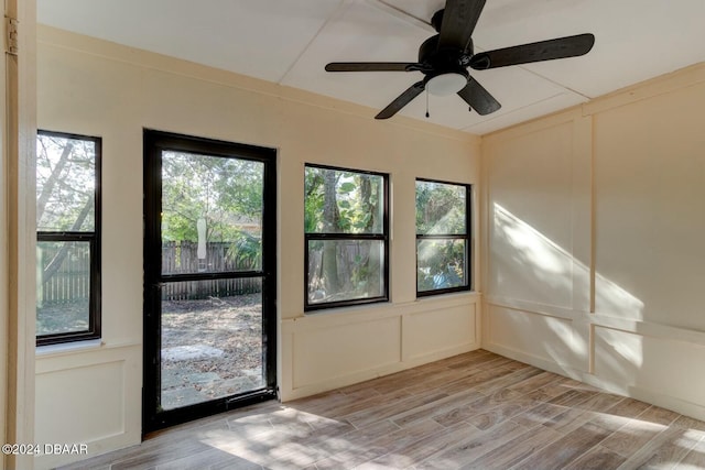 unfurnished sunroom featuring ceiling fan and a healthy amount of sunlight