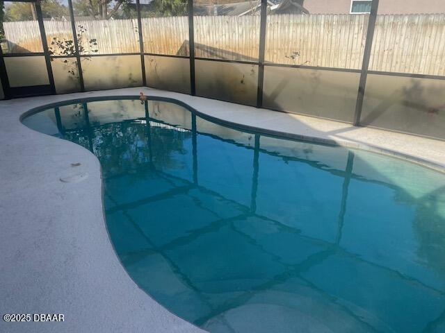 view of pool featuring glass enclosure and a fenced in pool