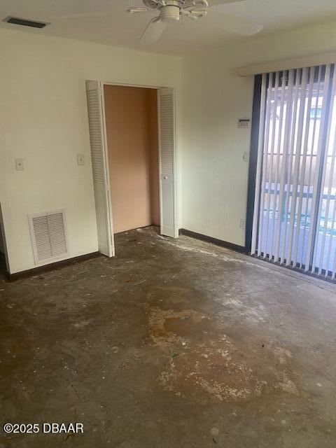 spare room with baseboards, visible vents, concrete flooring, and ceiling fan