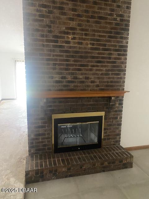 details featuring baseboards and a large fireplace