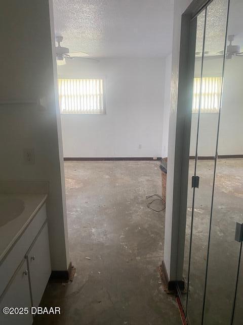 bathroom featuring baseboards, a textured ceiling, ceiling fan, and vanity