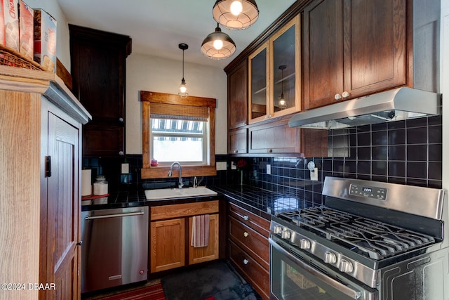 kitchen featuring decorative backsplash, appliances with stainless steel finishes, hanging light fixtures, and sink