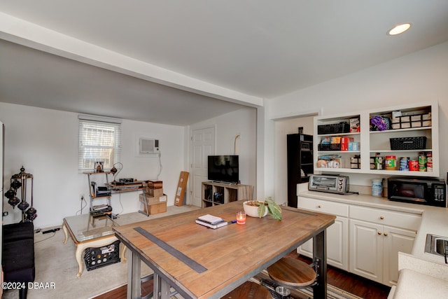 dining room featuring a wall unit AC and dark hardwood / wood-style flooring