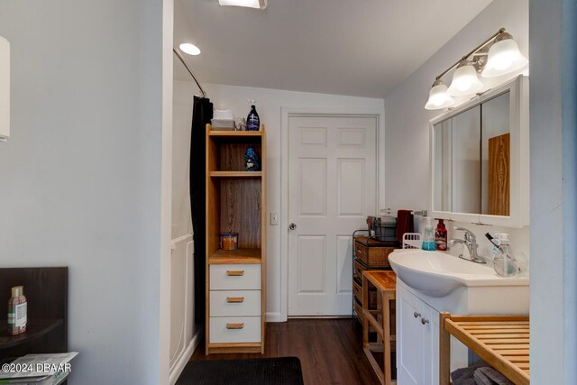 bathroom with hardwood / wood-style floors, lofted ceiling, and vanity