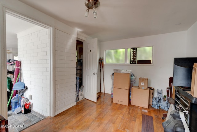 interior space featuring light wood-type flooring and brick wall