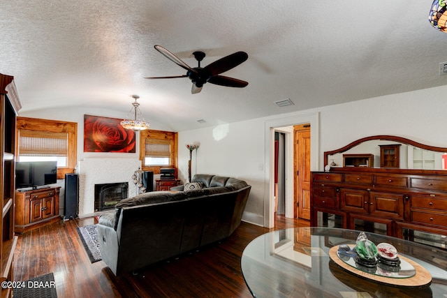 living room with ceiling fan, lofted ceiling, a textured ceiling, and dark hardwood / wood-style floors