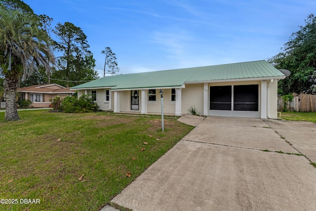 ranch-style home featuring fence, metal roof, covered porch, stucco siding, and a front lawn