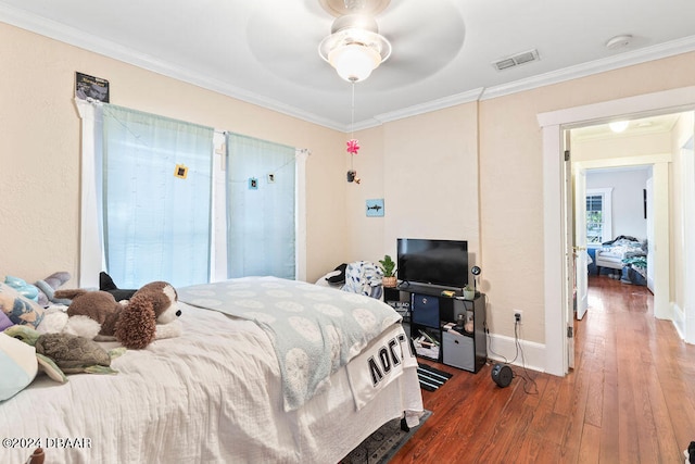 bedroom featuring dark wood-type flooring, ceiling fan, and ornamental molding