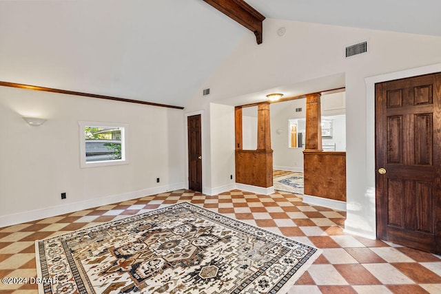 empty room with high vaulted ceiling, decorative columns, and beam ceiling