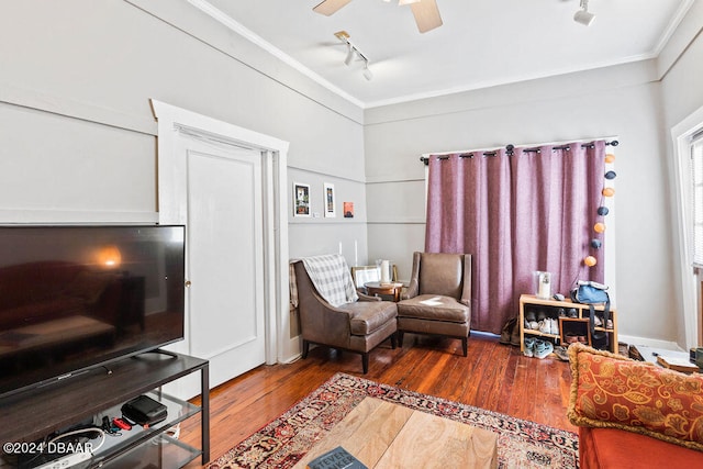 sitting room with hardwood / wood-style floors, track lighting, ceiling fan, and crown molding