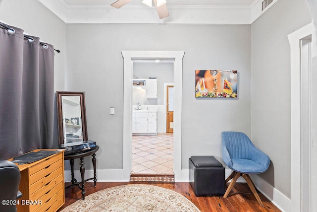 living area with hardwood / wood-style floors, ceiling fan, and crown molding