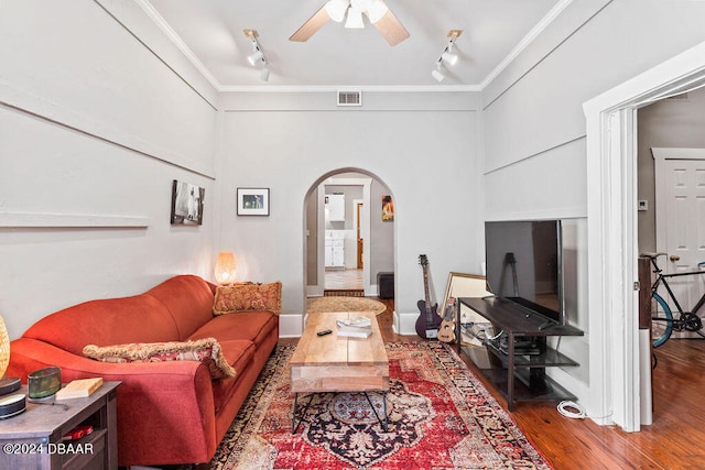 living room featuring wood-type flooring, rail lighting, and crown molding