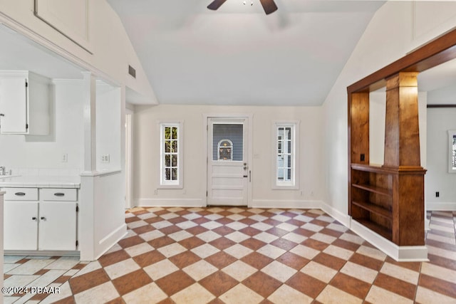 foyer entrance featuring decorative columns, vaulted ceiling, and ceiling fan