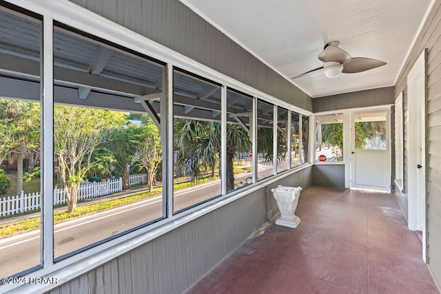 unfurnished sunroom featuring ceiling fan