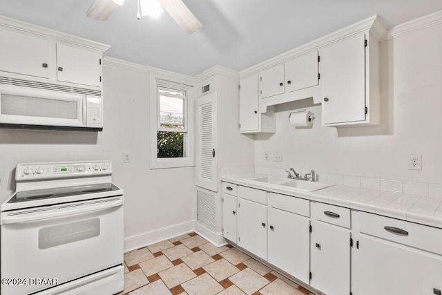 kitchen featuring ornamental molding, white cabinetry, sink, tile counters, and white appliances