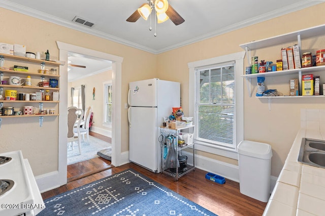 kitchen with tile countertops, dark wood-type flooring, white appliances, and crown molding