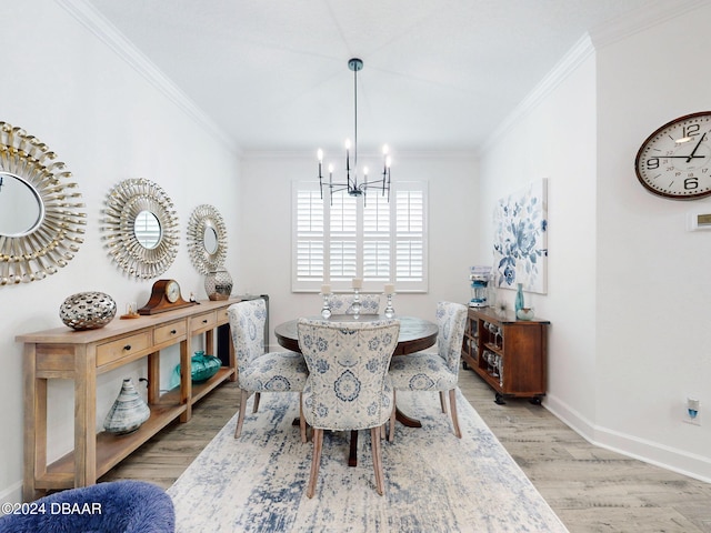 dining area featuring ornamental molding, a notable chandelier, and light wood-type flooring