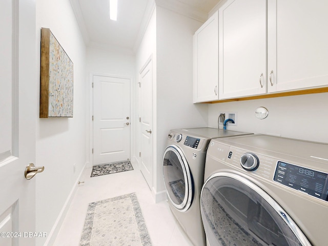 laundry room featuring washer and clothes dryer, ornamental molding, and cabinets