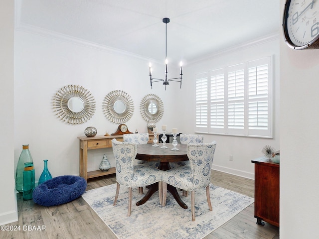 dining area with an inviting chandelier, crown molding, and light hardwood / wood-style flooring