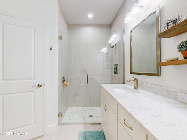 bathroom with vanity, a shower with shower door, and tile patterned floors