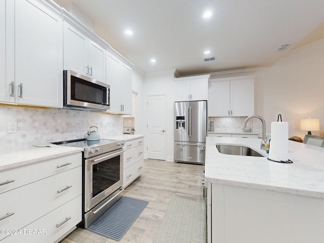 kitchen with sink, ornamental molding, white cabinets, and high quality appliances