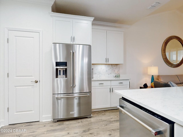 kitchen with white cabinetry, light wood-type flooring, ornamental molding, and appliances with stainless steel finishes