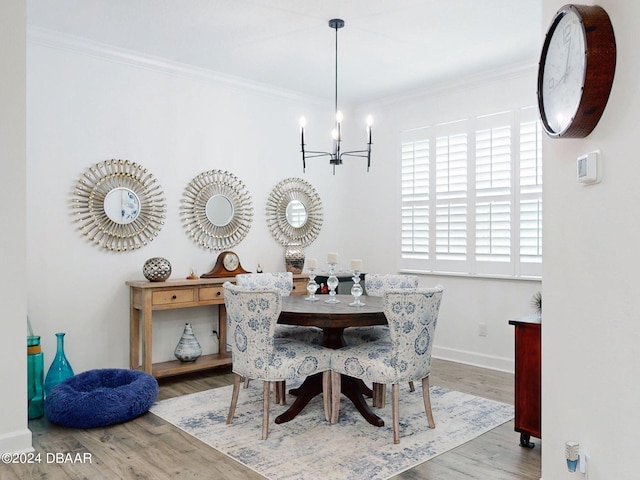 dining area featuring hardwood / wood-style floors, ornamental molding, and a chandelier