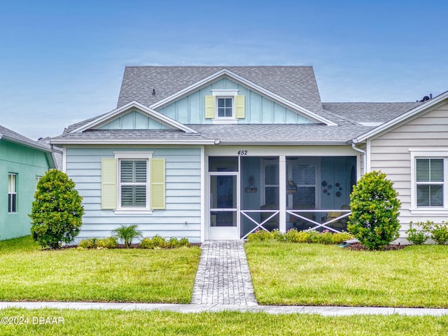 view of front of property featuring a front lawn and a sunroom