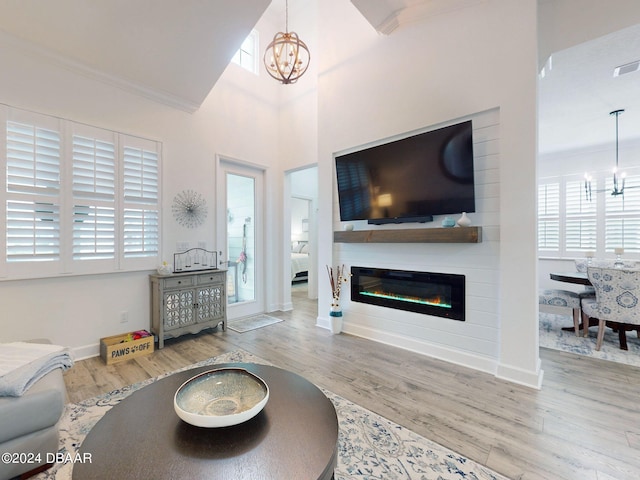 living room featuring crown molding, hardwood / wood-style flooring, and a chandelier