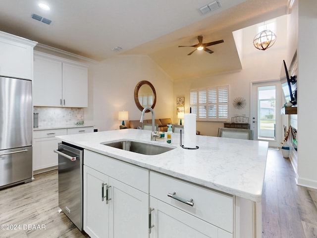 kitchen featuring stainless steel appliances, a kitchen island with sink, sink, and white cabinets