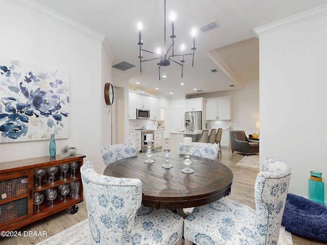 dining room with crown molding, a chandelier, and light hardwood / wood-style floors