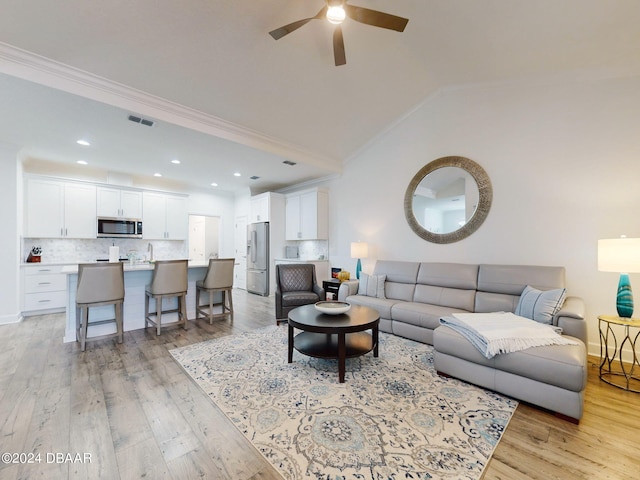 living room featuring crown molding, ceiling fan, lofted ceiling, and light hardwood / wood-style floors